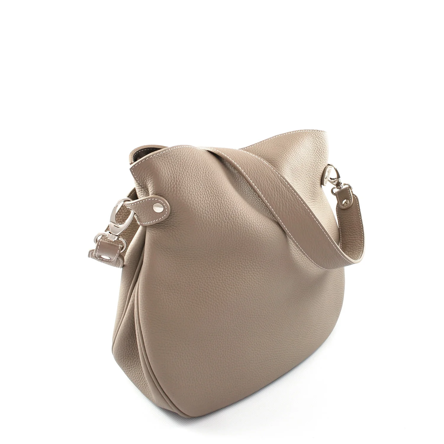 Un sac à main en cuir beige avec une seule bandoulière et du matériel argenté, positionné en angle.