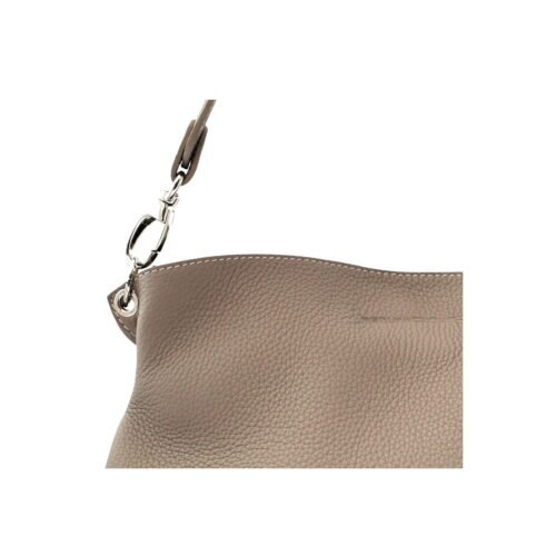 Gros plan d'un sac en cuir texturé taupe avec un fermoir argenté sur une sangle.