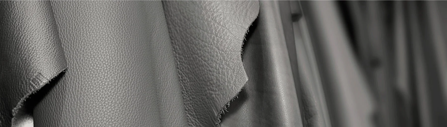 Gros plan de morceaux suspendus de cuir noir avec une surface texturée.