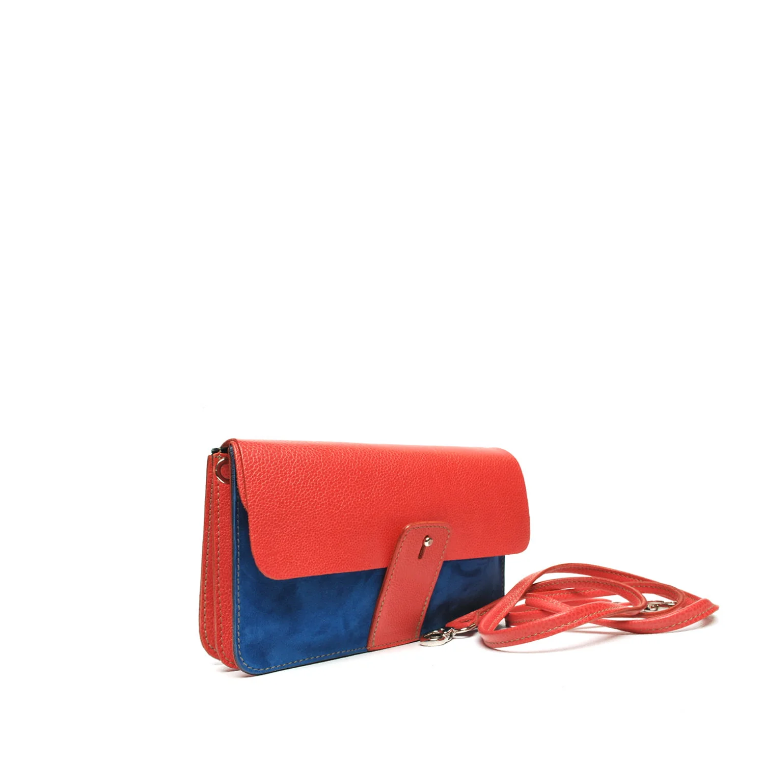 Un sac à main en cuir rouge et bleu avec une bandoulière, présenté sur un fond blanc.