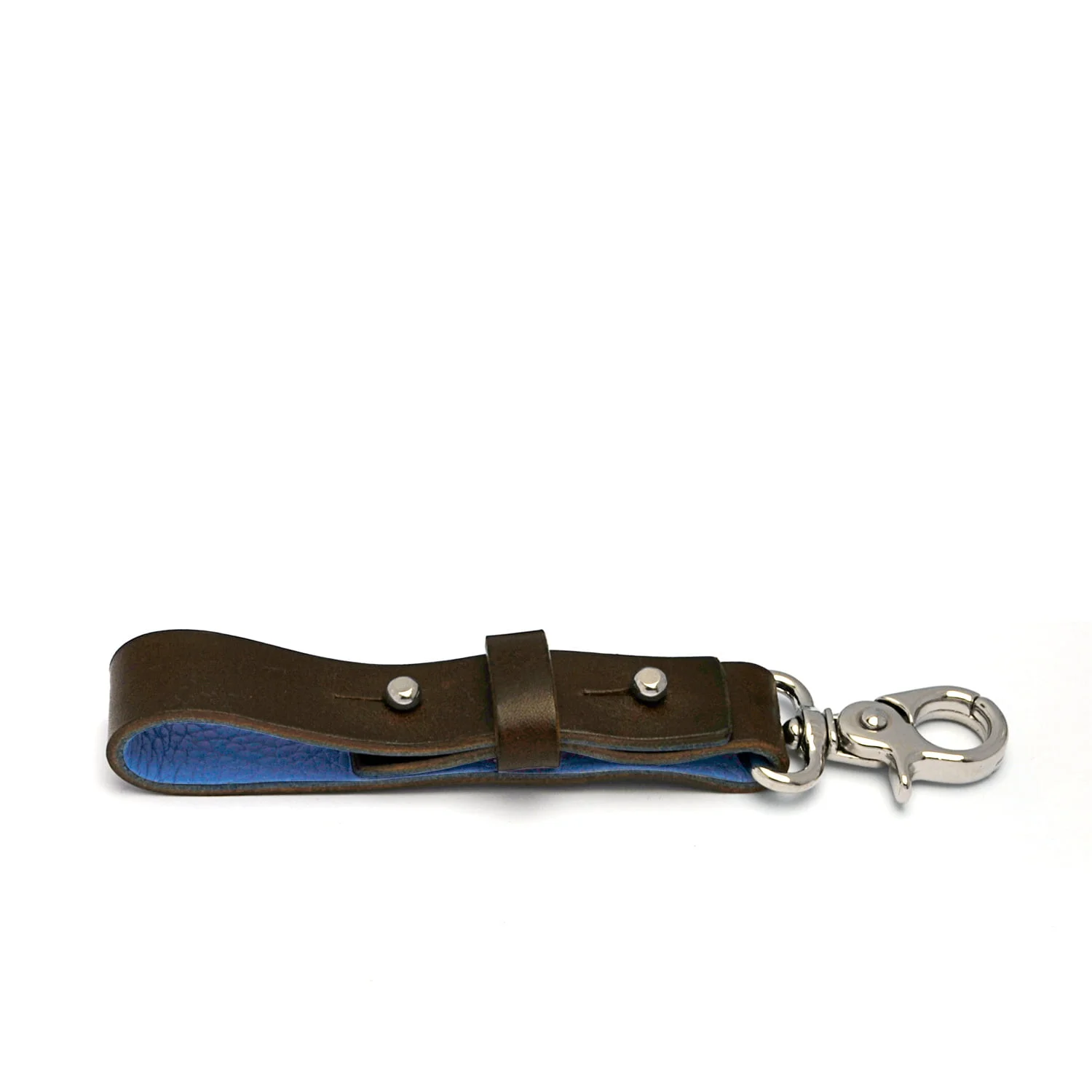 Un porte-clés en cuir marron avec un intérieur bleu et un fermoir en métal à une extrémité, posé à plat sur un fond blanc.
