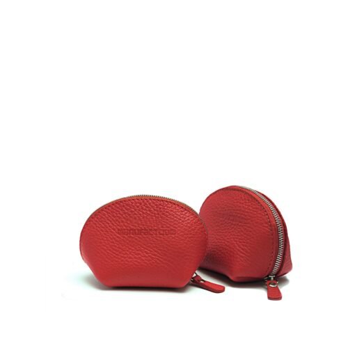 Deux petites pochettes en cuir rouge avec fermetures éclair, l'une debout et l'autre légèrement ouverte, sur fond blanc.