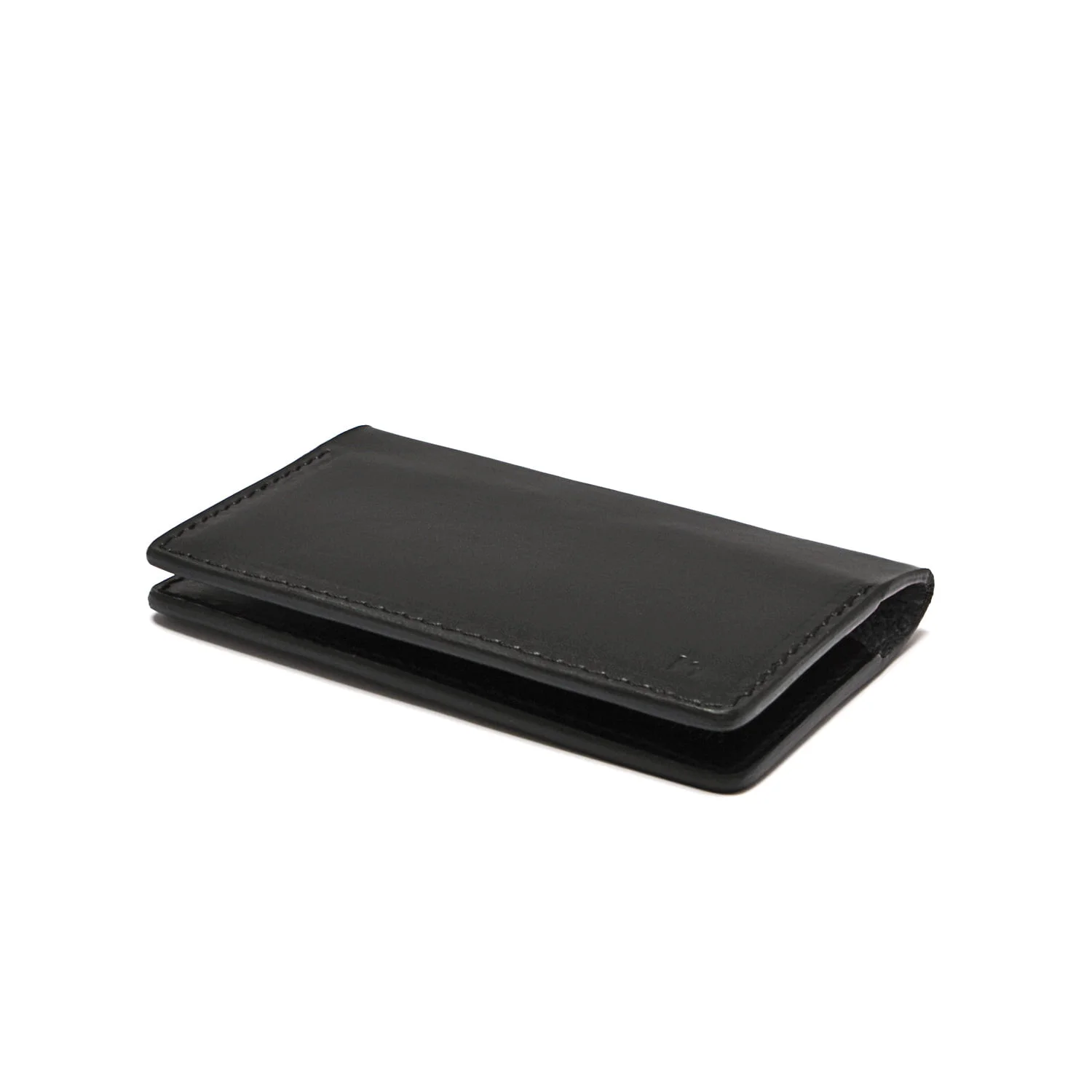 Un portefeuille en cuir noir fermé reposant sur une surface blanche.