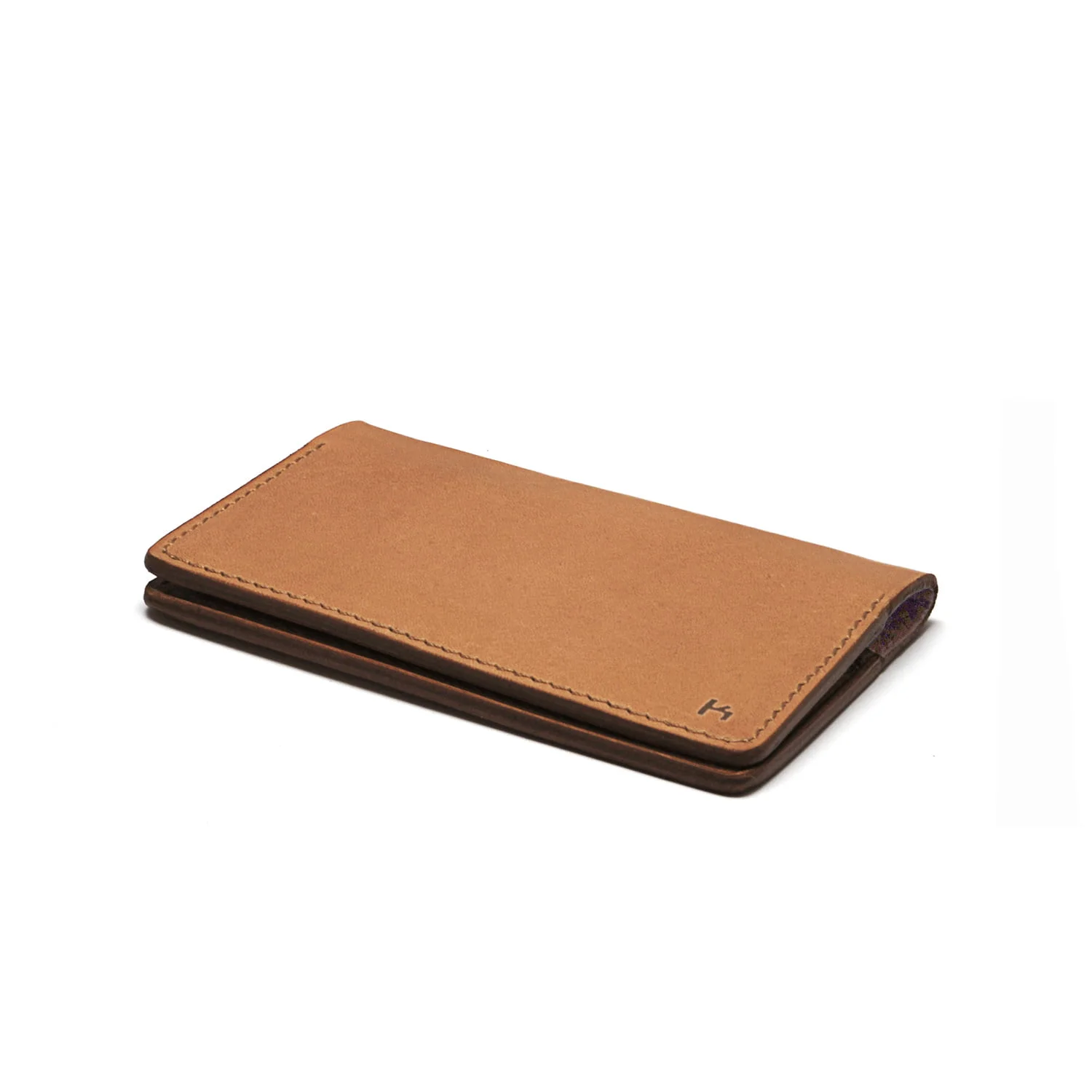 Un portefeuille en cuir fermé de couleur beige neutre est posé à plat sur un fond blanc.