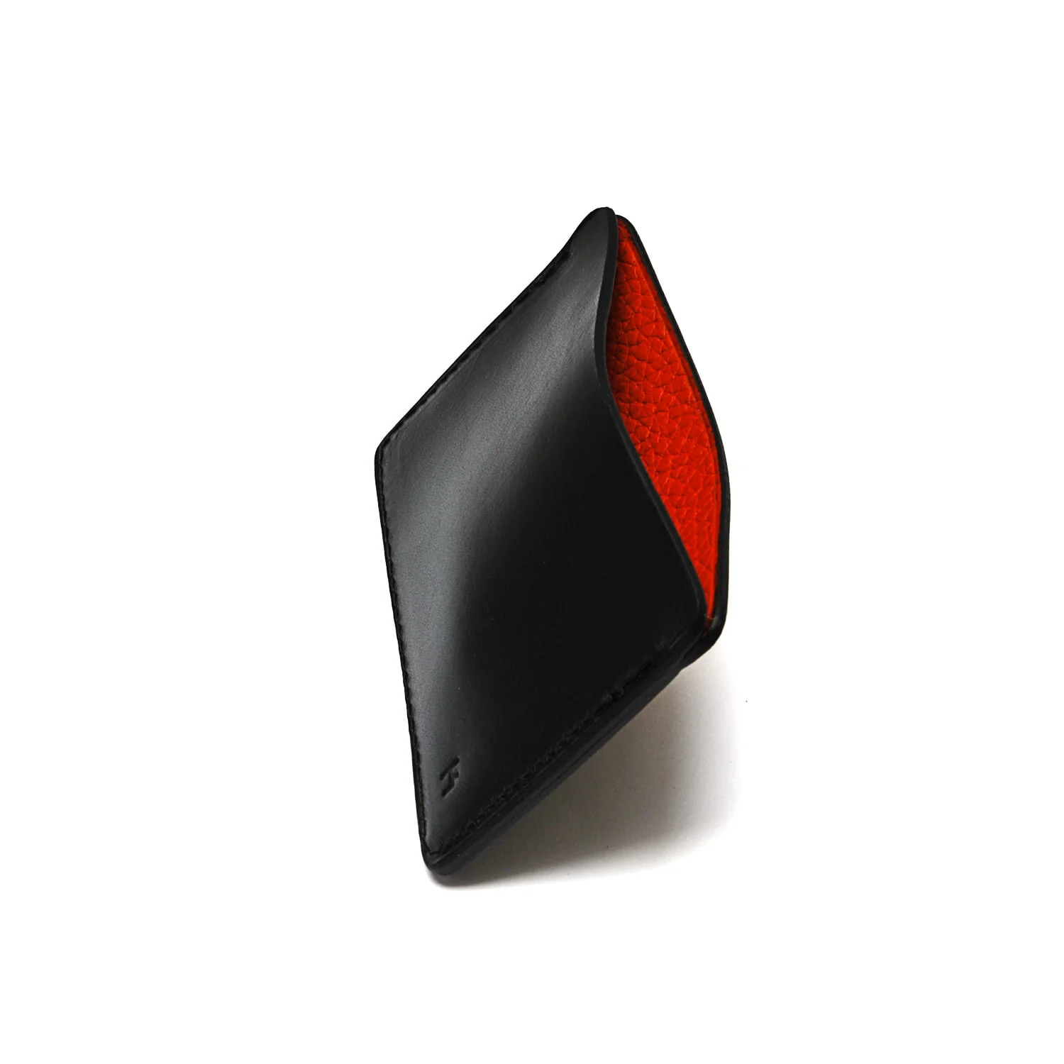 Un portefeuille en cuir noir avec un intérieur rouge visible, debout sur un fond blanc uni.