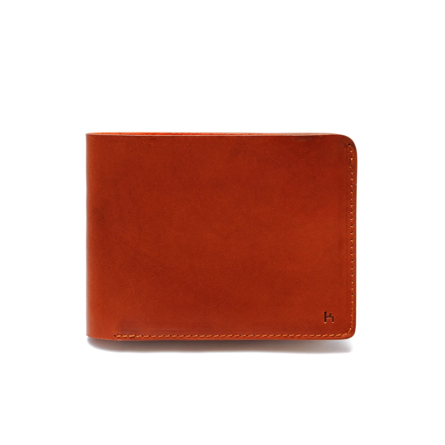 Un portefeuille fermé en cuir marron avec une surface lisse et des coutures visibles sur les bords.