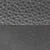 Gros plan d'une surface noire texturée avec une moitié supérieure à motifs et une moitié inférieure lisse.