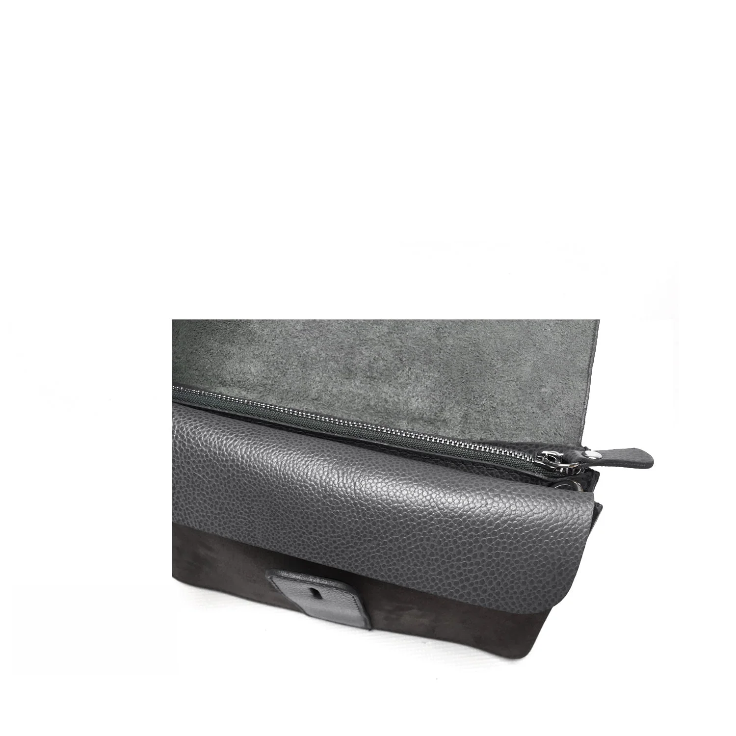 Gros plan d'un sac en cuir gris avec une fermeture éclair et un rabat noirs.