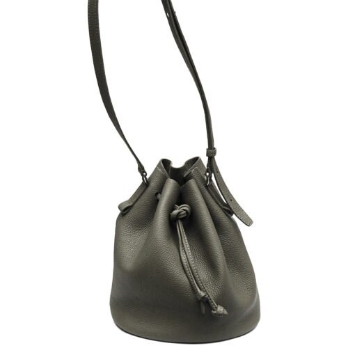 Un sac seau en cuir vert avec une fermeture à cordon et une bandoulière, debout.
