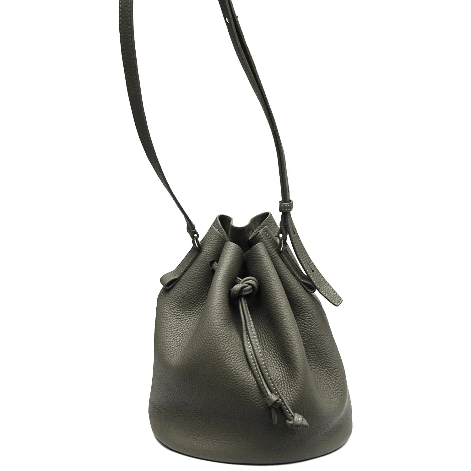Un sac seau en cuir vert avec une fermeture à cordon et une bandoulière, debout.
