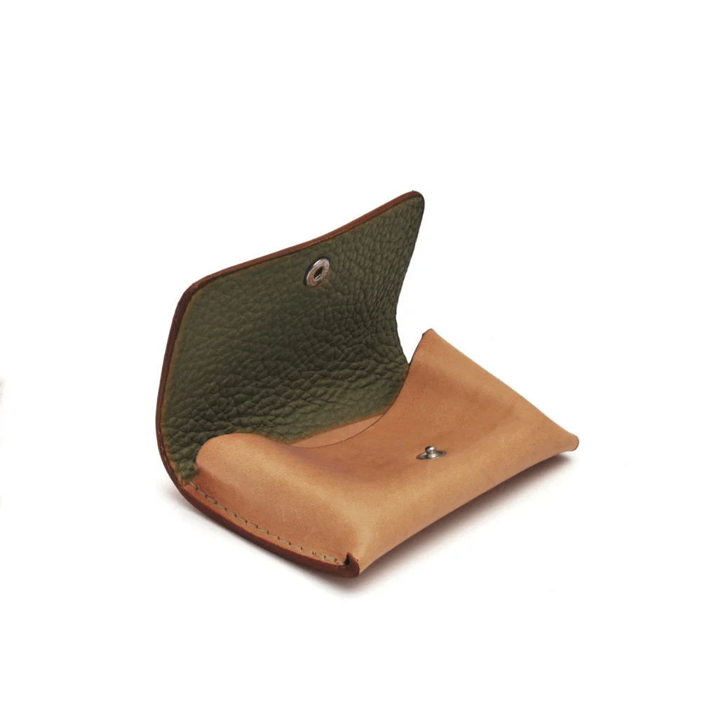 Porte-monnaie en cuir avec un extérieur marron clair et un intérieur vert foncé, ouvert avec une fermeture à bouton-pression.