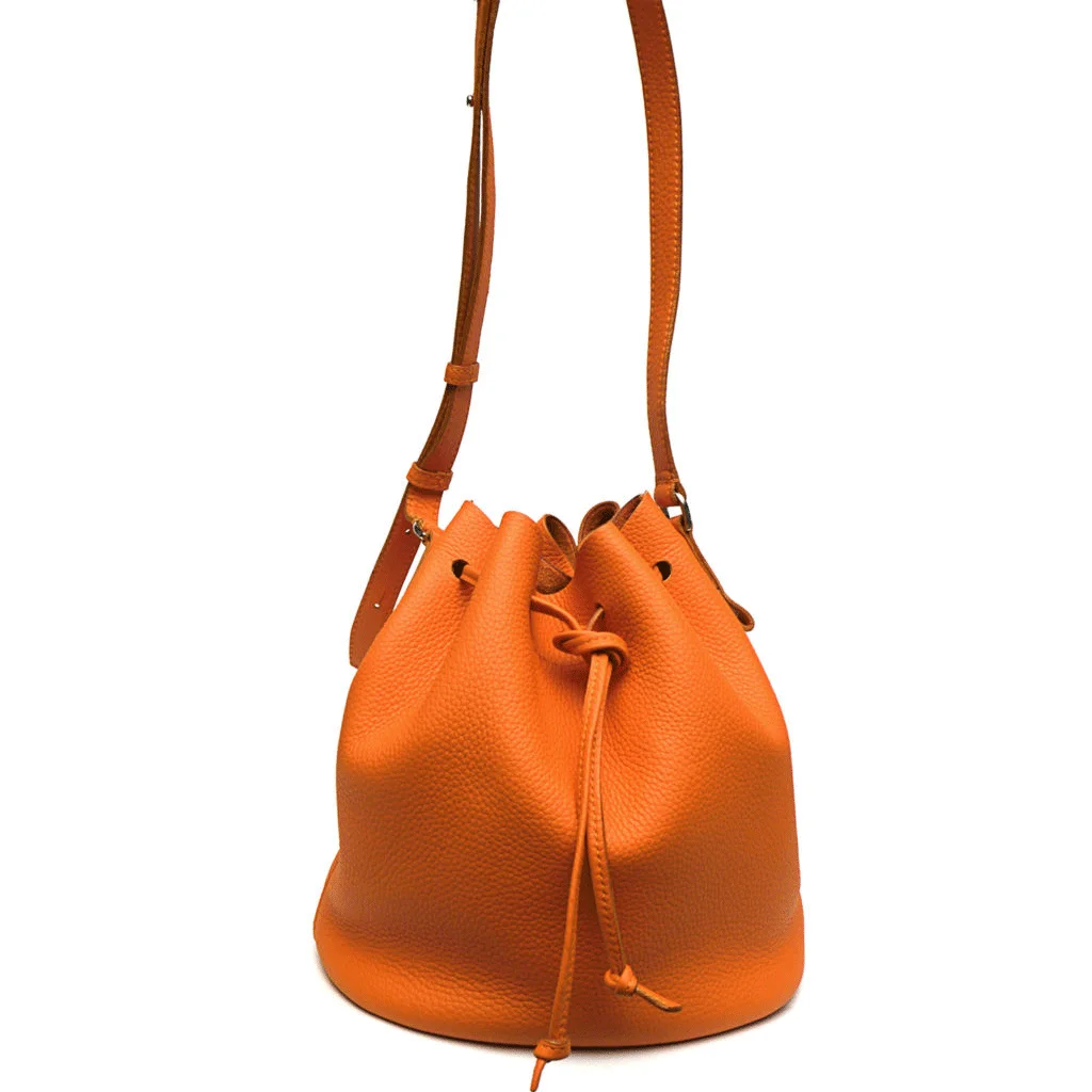 Sac seau en cuir orange avec cordon de serrage et bandoulière.