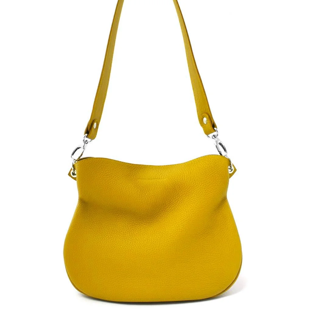 Le sac bandoulière en cuir jaune JUDY est doté d'anneaux en métal argenté et d'une large bandoulière.