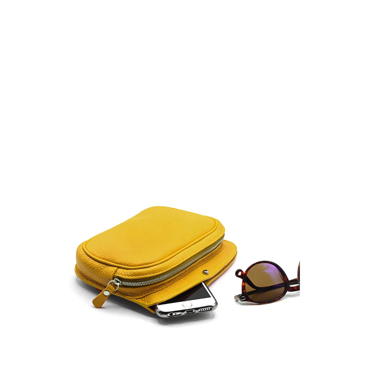 Une pochette MAE en cuir jaune avec un téléphone partiellement à l'intérieur se trouve à côté d'une paire de lunettes de soleil.