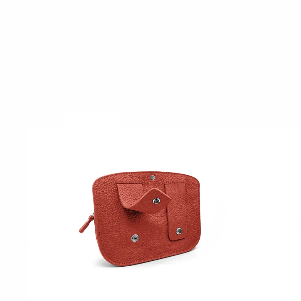Le MAE Sangle, une pochette compacte en cuir rouge dotée d'un rabat enveloppant et d'une fermeture à bouton-pression, est présenté sur un fond blanc uni.