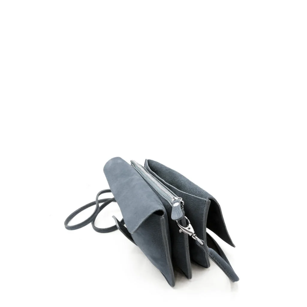 Sac à main en cuir gris avec deux compartiments principaux et une bandoulière, présenté sur une surface blanche plane.