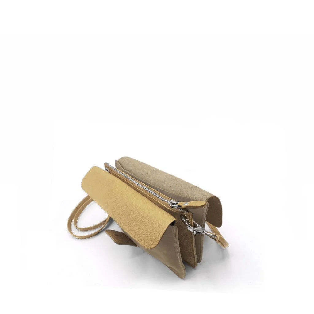 Un petit sac à bandoulière en cuir beige et beige avec une fermeture éclair et des fermetures magnétiques, présenté sur un fond blanc.