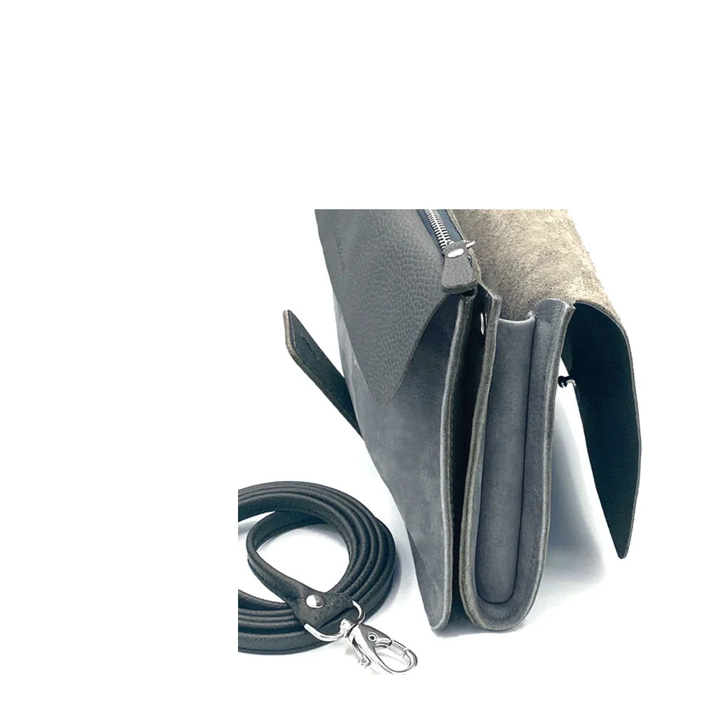 Vue latérale d'un sac à main en cuir gris avec une bandoulière amovible et une ouverture supérieure zippée.