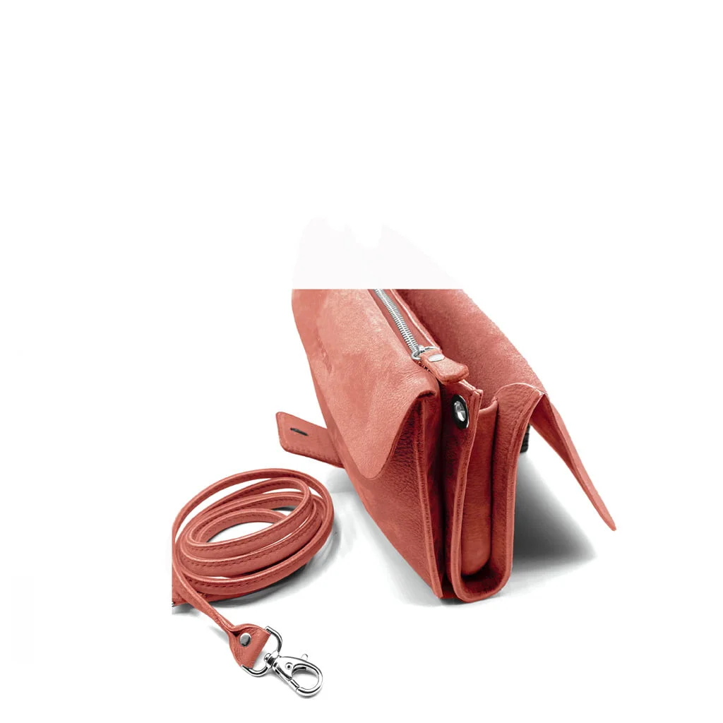 Un sac à main en cuir rose avec une fermeture éclair est présenté à côté d'une bandoulière amovible avec un fermoir en métal.