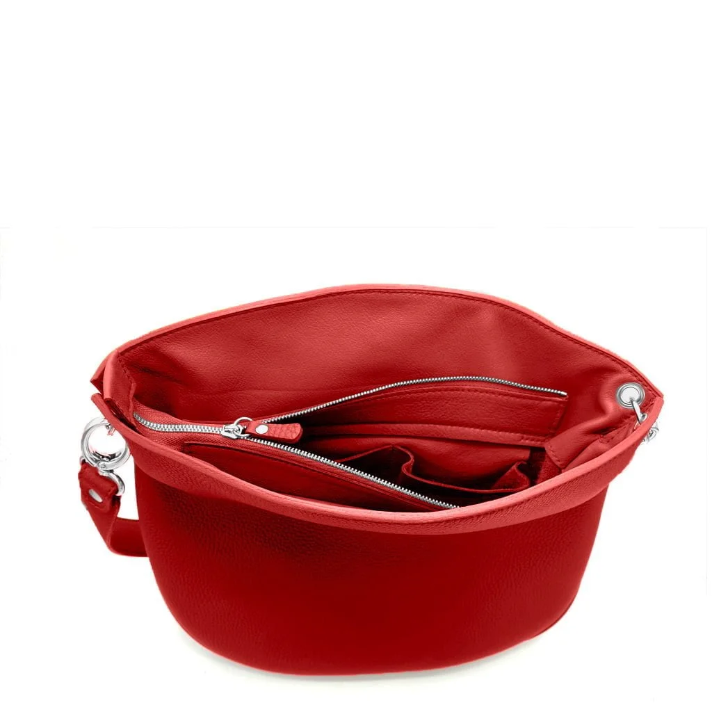 Un sac à main en cuir rouge avec une fermeture éclair argentée et un dessus ouvert, affichant ses compartiments intérieurs et une bandoulière.