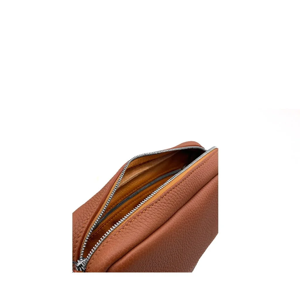 Gros plan d'un sac en cuir marron partiellement ouvert avec une fermeture éclair argentée visible et un intérieur beige.