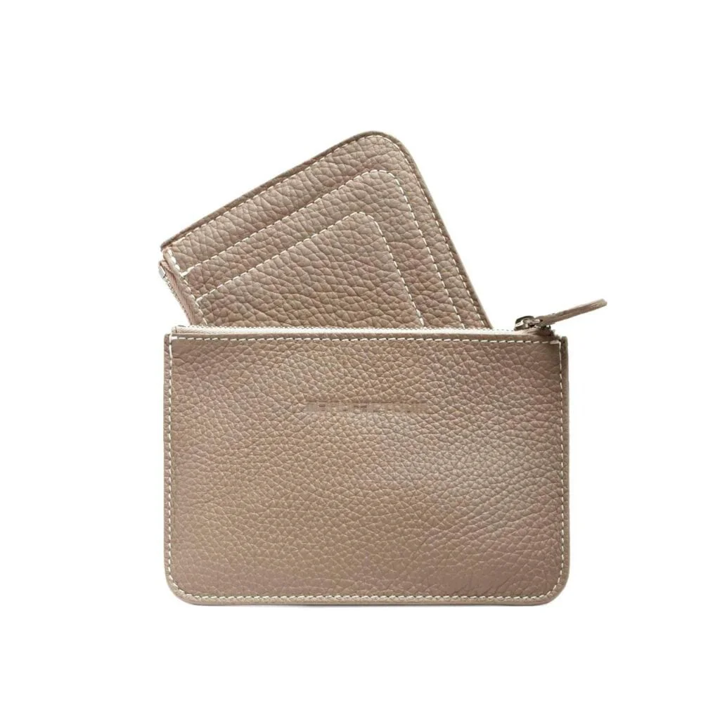 Une pochette en cuir texturé taupe avec une fermeture éclair, contenant trois porte-cartes en cuir assortis.