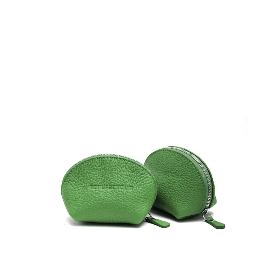 Deux petites pochettes en cuir vert semi-circulaires à fermeture éclair, rappelant les modèles classiques de porte monnaie, sont élégamment placées sur un fond blanc.