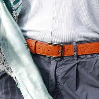 Une personne portant une chemise bleue et un pantalon avec une ceinture orange.