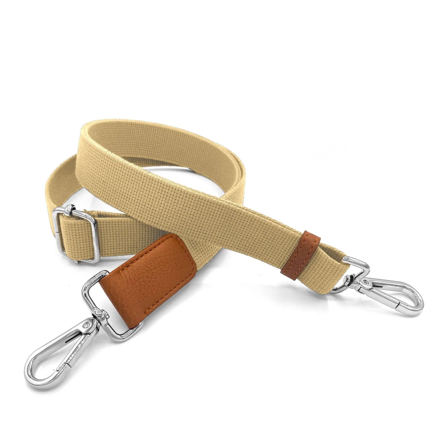 Un bracelet en tissu beige avec des clips en métal argenté aux deux extrémités, avec un accent en cuir marron.