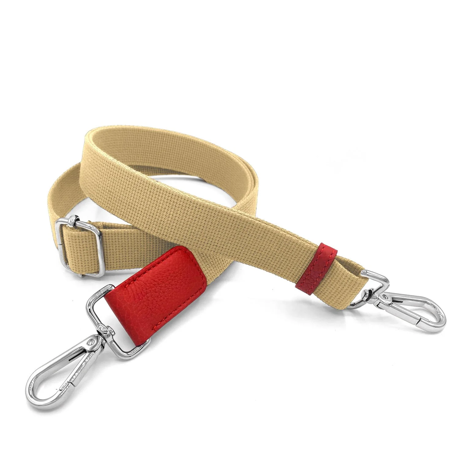 Un bracelet en tissu beige avec des accents de cuir rouge et des clips en métal argenté à chaque extrémité, enroulé sur un fond blanc.