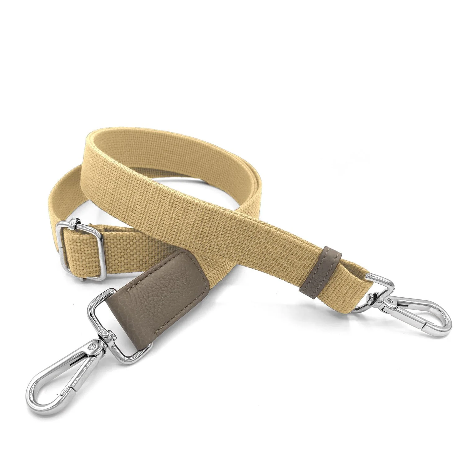 Un bracelet en tissu beige avec boucle réglable et deux fermoirs pivotants en métal argenté à chaque extrémité.
