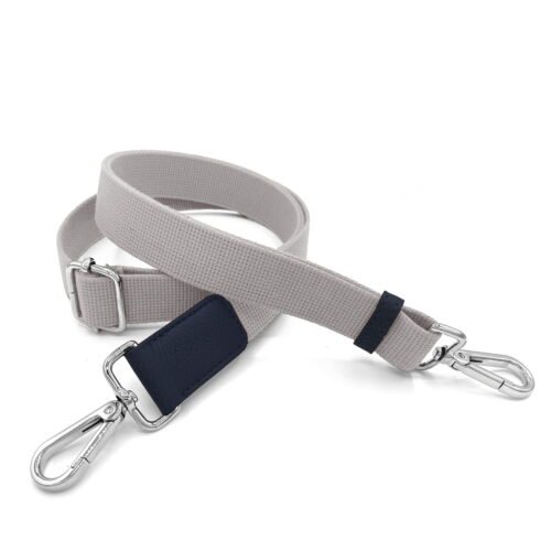 Un bracelet en tissu beige avec un fermoir en métal à chaque extrémité et un accent bleu.