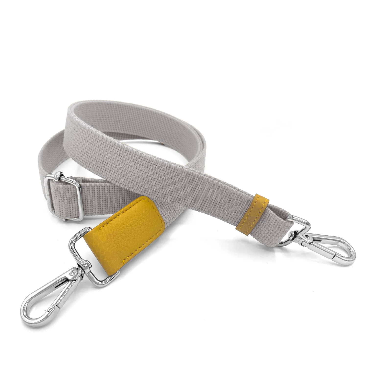 Un bracelet en tissu gris avec deux clips argentés et un accent en cuir jaune.