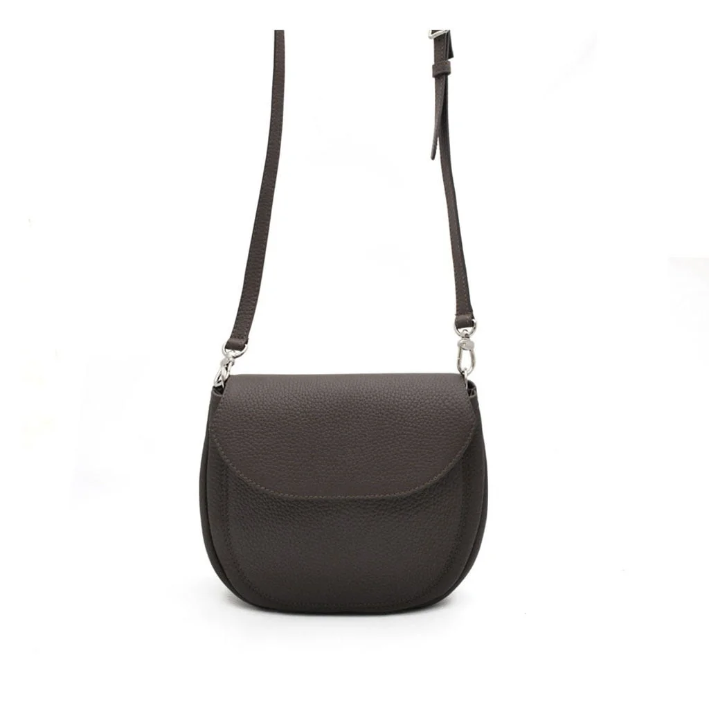 Un sac à bandoulière en cuir noir avec une longue bandoulière réglable et une fermeture à rabat incurvé.