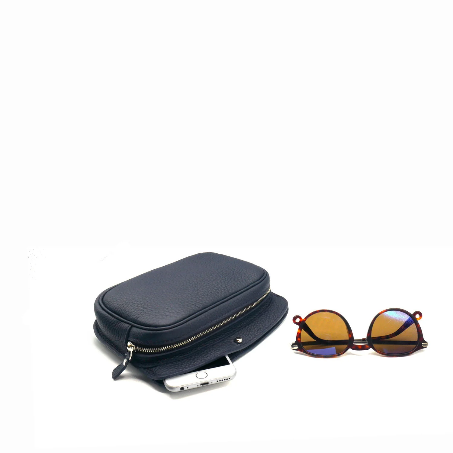 Une pochette noire zippée avec un smartphone blanc partiellement à l'intérieur et une paire de lunettes de soleil marron à côté.
