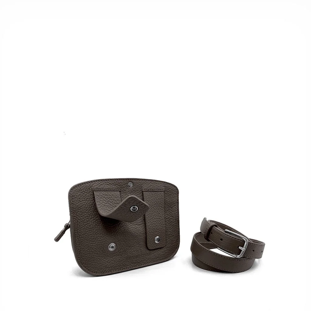 Une petite pochette en cuir marron avec une fermeture éclair et une poche se trouve à côté d'une bandoulière en cuir amovible assortie.