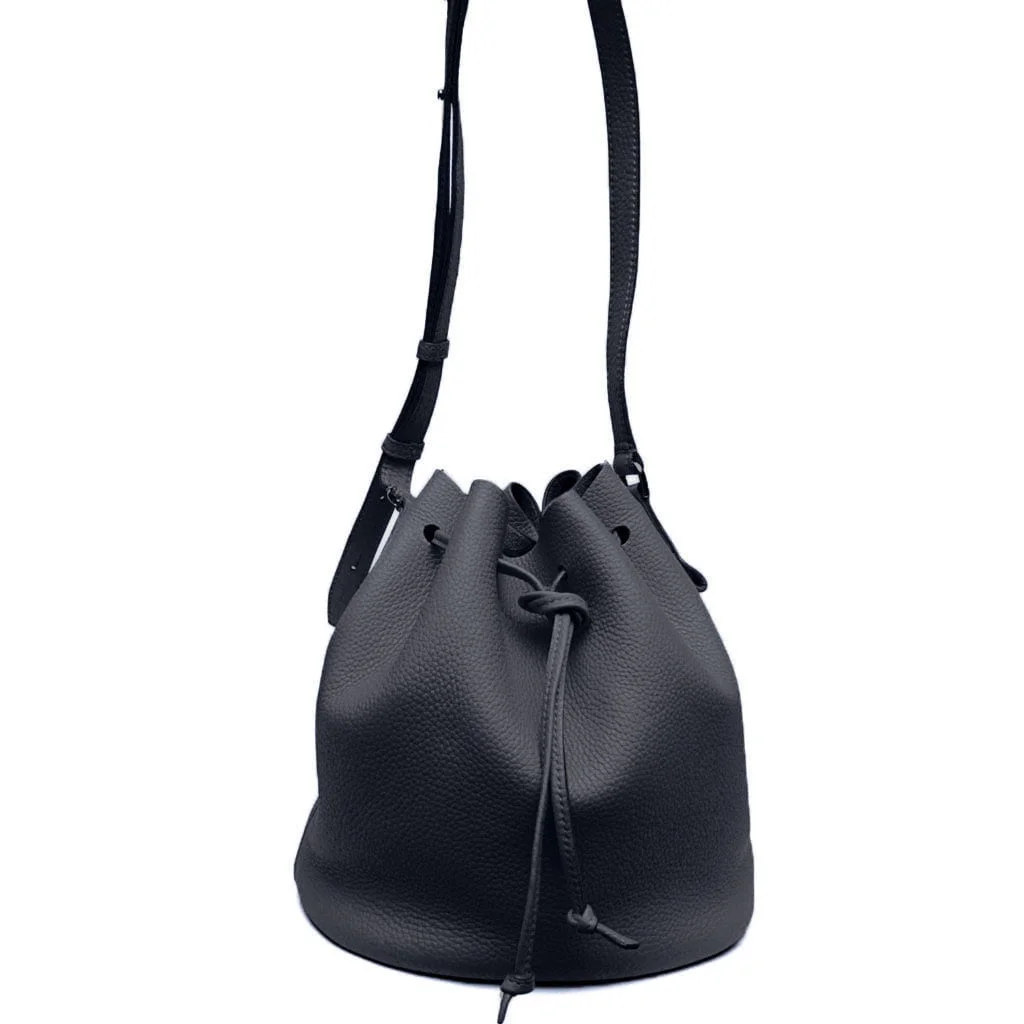 Un sac seau en cuir noir avec cordon de serrage et bandoulière réglable.