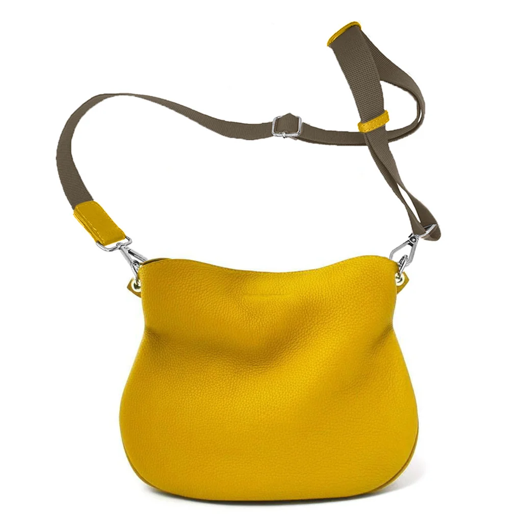 Sac à main en cuir jaune avec une large bandoulière marron réglable, présenté sur un fond blanc.