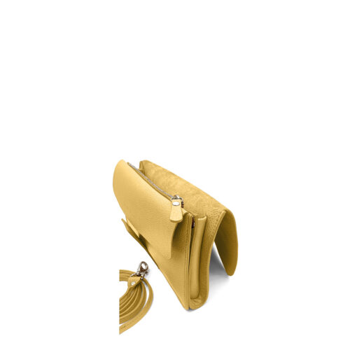 Un sac à bandoulière en cuir jaune, doté d'une poche zippée, d'un compartiment ouvert et d'une bandoulière amovible assortie, exposé à proximité.