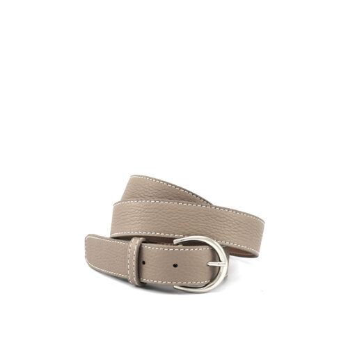 Une ceinture en cuir beige avec des coutures blanches et une boucle ronde argentée, enroulée en boucle.